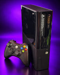 Black Xbox 360 E console and wireless controller on purple background